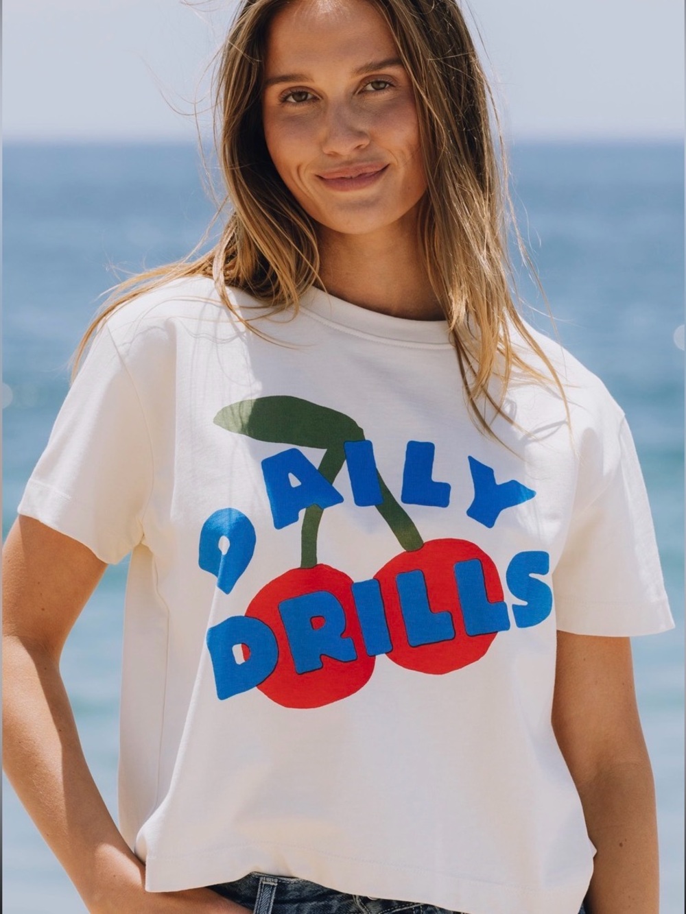 Daily Drills White Short Sleeve Tee with Red Cherry Graphic and Blue Logo
